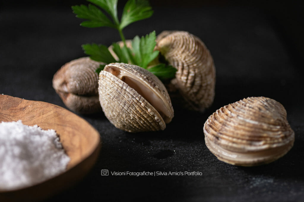 Tartufi di mare su piatto di ardesia con prezzemolo tartufi di mare