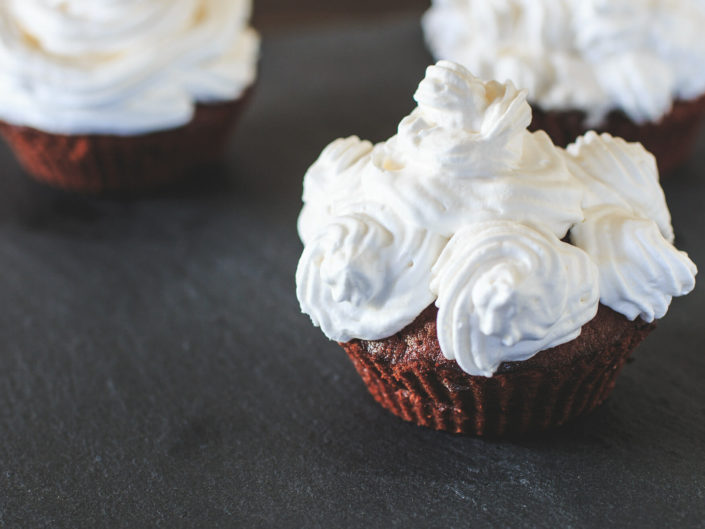 Cupcake al cioccolato e panna con decorazioni a piccole spirali