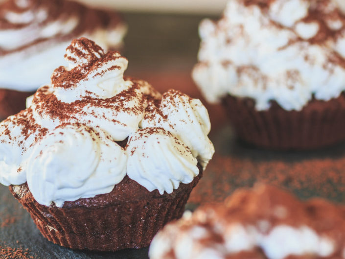 Foto formato portrait di diversi cupcakes al cioccolato e panna